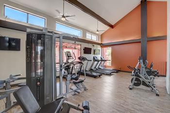 A gym with a variety of equipment including treadmills, weights, and a television at Glen at Mesa, Mesa, AZ, 85201